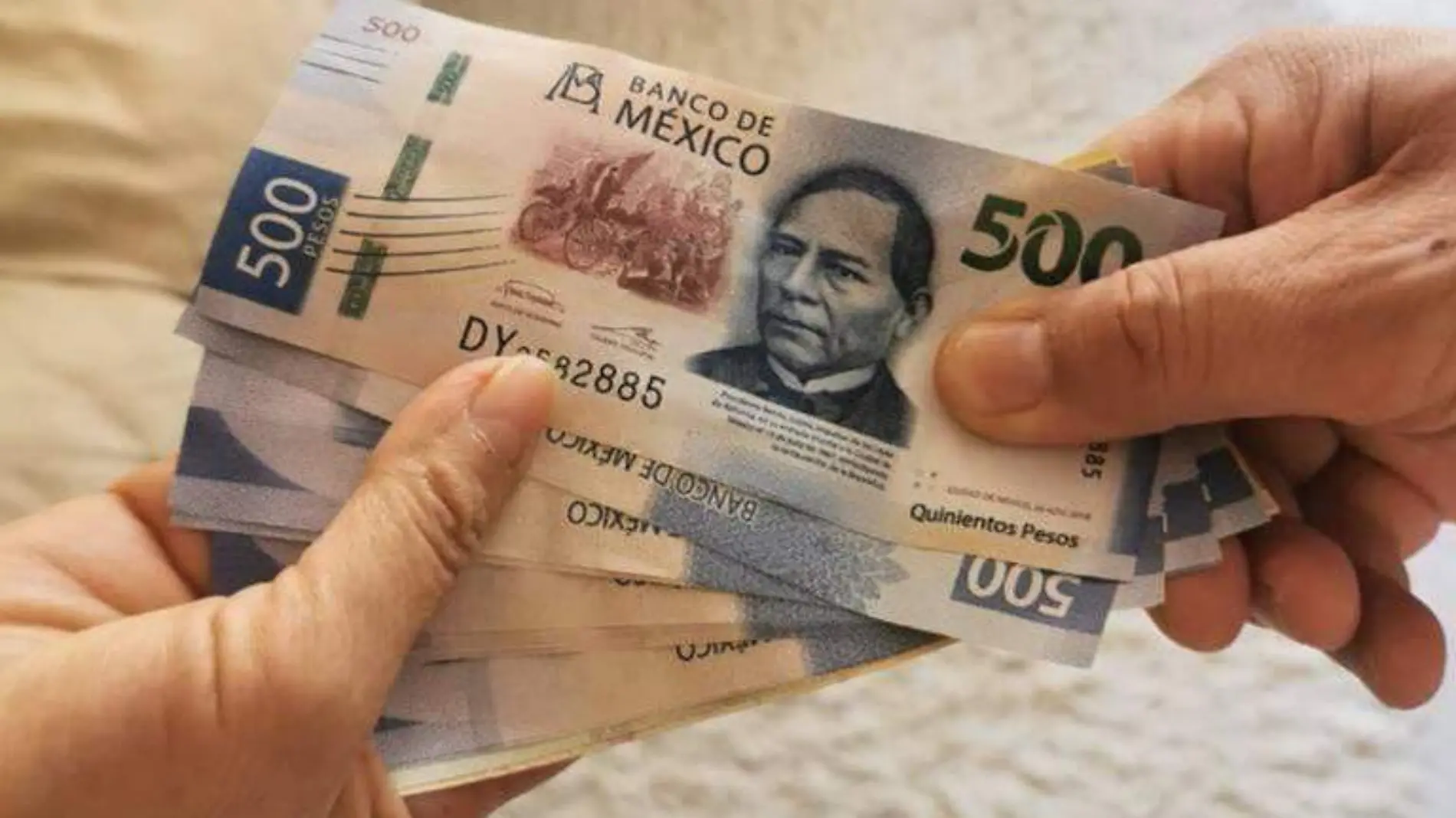 manos agarrando billetes de 500